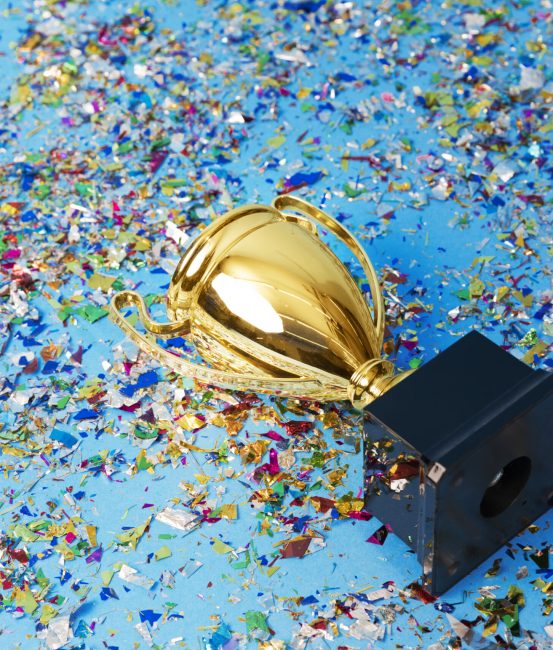 Gold trophy on a confetti background